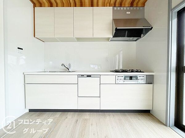 収納力に優れたシステムキッチン。三口コンロと広いシンクでお料理がはかどります。足元までしっかり活用できるスライド収納も、使い勝手が良好です