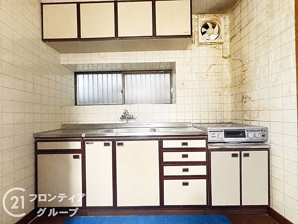 木目調のパネルが温かみを演出する、収納豊富なシステムキッチンです。正面に窓があるため手元が明るく、換気もしやすい設計となっており、毎日のお料理時間を快適かつ清潔にサポートしてくれます