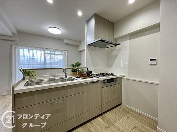 木目の美しいフラットな対面式カウンターと清潔感のあるホワイトの壁面が調和していますね！広々とした作業スペースが毎日の調理時間を楽しく快適にしてくれます