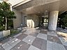 エントランス：木々の緑に彩られたエントランスアプローチ。広々としたタイル貼りの通路が、居住者を優しく迎え入れます。