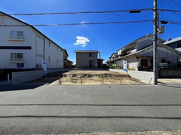 青空が広がる分譲地。周辺には住宅が立ち並び、新しい暮らしを始めるのに適した環境です。理想の住まいをこの場所で実現しませんか。