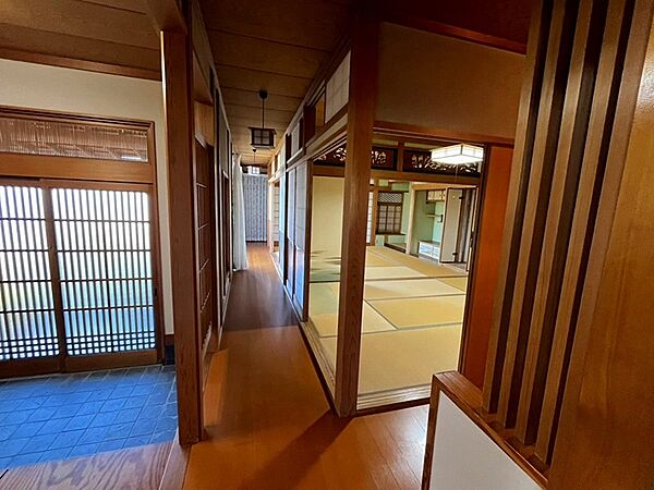 趣ある玄関を抜けると、畳敷きの広間が広がります。陽光が差し込む廊下は、和の温もりを感じさせます。