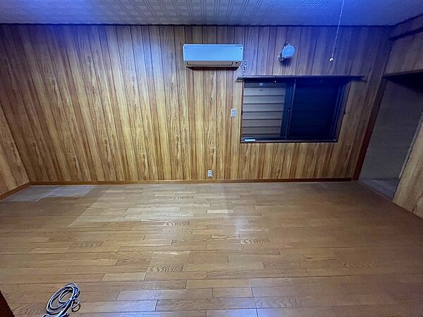 落ち着いた木目調の内装が魅力の洋室です。エアコン完備で、一年中快適にお過ごしいただけます。多様な家具配置が可能な空間で、あなただけの居室を演出できます。