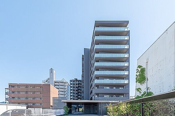 青空に映える、スタイリッシュな外観のマンションです。開放感のあるガラスバルコニーが目を引きます。都会的な暮らしをサポートする住まいです。