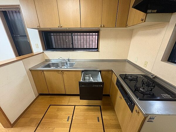 食洗機付きのシステムキッチンで、調理スペースも広く使いやすいL字型です。上部の吊戸棚には収納力もあります。
