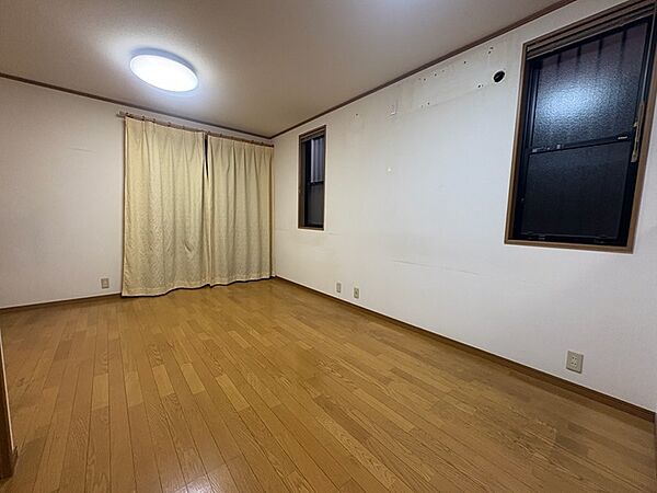 フローリングの床が広がる、明るい居室です。窓が複数あり、光を取り込みやすい空間で、快適にお過ごしいただけます。