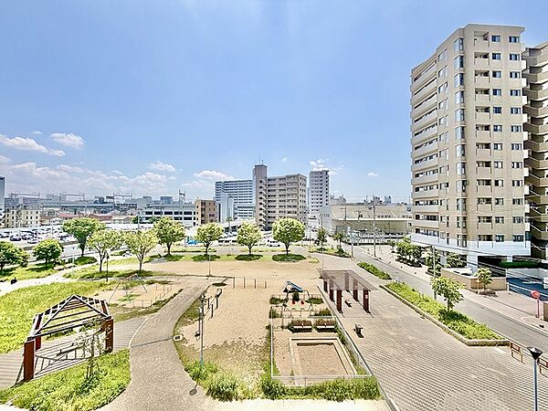 広がる青空と開放感あふれる眺望。公園の緑が目に優しく、都市の利便性と穏やかな住環境を享受できます。