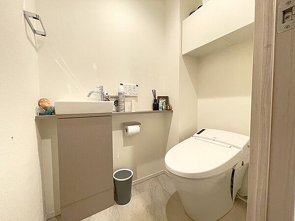 タンクレス節水トイレを採用。手洗いカウンターと収納棚を備え、機能性とデザイン性を兼ね備えています。