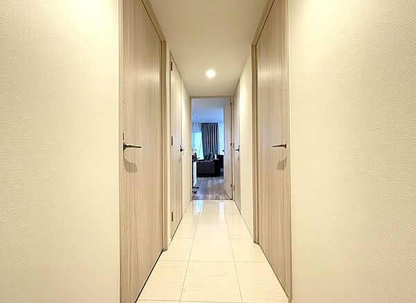 光沢のある床と明るい壁が印象的な廊下は、住まい全体にシックな印象をもたらします。