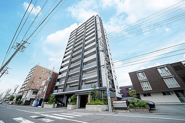 空に映える現代的なデザインのマンション。都市の利便性と居住性を兼ね備えた住まいです。
