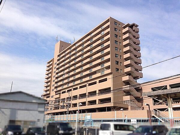穏やかな陽光が降り注ぐ、落ち着いた色合いの外観が魅力のマンション。多層階で、都市の眺望が期待できます。