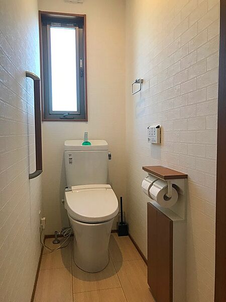 採光窓が設けられた明るいトイレスペース。手すりも設置されており、安心してご利用いただけます。