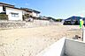 外観：陽光が降り注ぐ、開放的な更地です。隣接する家屋は平屋または2階建てで、周辺は閑静な住宅街の様子がうかがえます。建築プランの可能性が広がります。