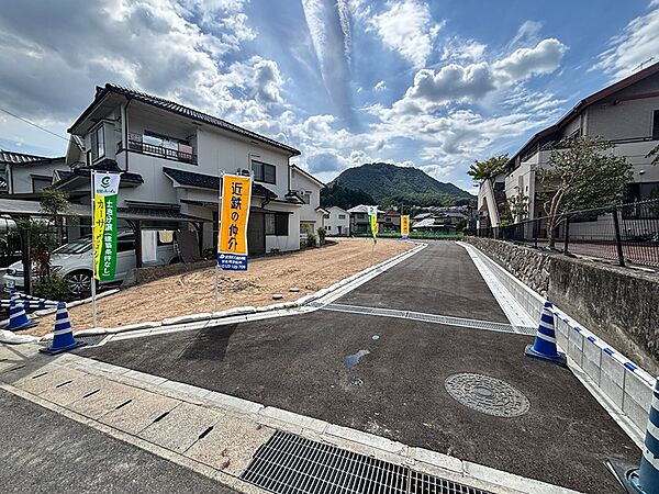 整備された道路と造成地が広がる分譲地。周辺には住居があり、穏やかな環境で新生活を始めるのにふさわしい場所です。