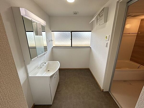 【リフォーム後写真】洗面脱衣所です。洗面台を新品交換し、床はクッションフロアを貼り、天井と壁はクロスを張り替えました。清潔な空間になりますね。
