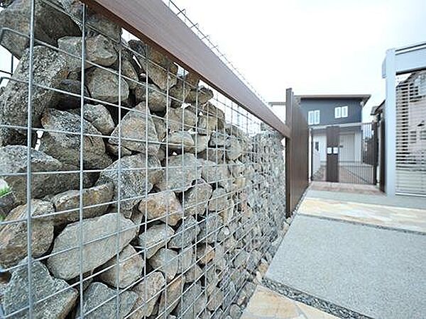 【プラン例】ダイナミックな門柱。金属でできた箱型メッシュの中に石を入れたシンプルなデザイン。木板でアクセントをつけて住宅街でも一際目立つ存在に。