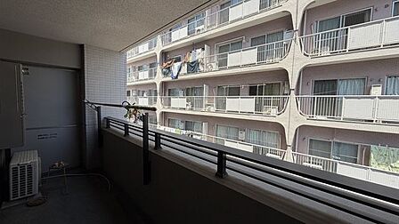 バルコニーには手すりと物干し用金具が設置されており、壁面には非常時の避難用の隔て板が設けられています。
