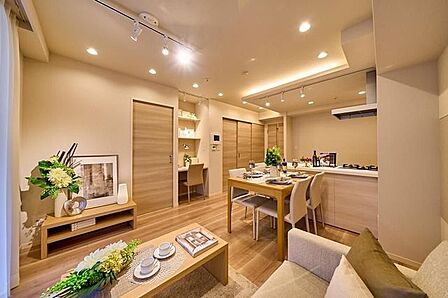 ナチュラルな木目調のフローリングと建具で統一された室内には、天井のダウンライトやスポットライトに加え間接照明が配されており、壁面には作り付けのカウンターデスクや棚などの設備が整っています。