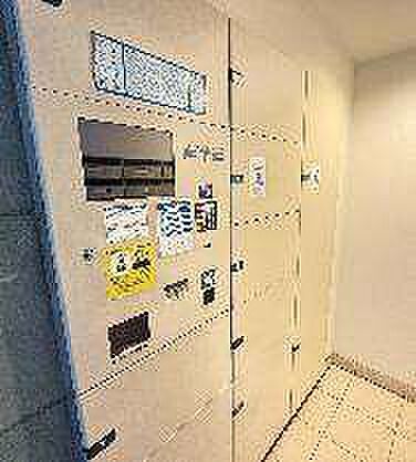 共用部分にはダイヤル錠付きの集合郵便受や大小さまざまな扉を備えた宅配ボックスが整然と設置されており、床面はタイル張りでフラットな仕上がりとなっています。