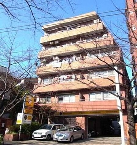 温かみのあるブラウン系の外壁タイルが印象的なマンション外観で、各階にバルコニーが配置されているほか、建物1階部分にはお車を格納できるガレージスペースが設けられています。