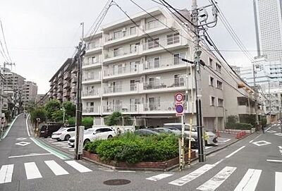 外観:白を基調とした外壁に各階バルコニーが配置されたマンションで、角地に位置し敷地内には駐車場や植栽スペースが整備されています。 外観:白を基調とした外壁に各階バルコニーが配置されたマンションで、角地に位置し敷地内には駐車場や植栽スペースが整備されています。