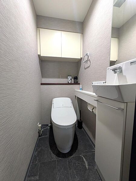 タイル張り、手洗い台・吊戸棚付のトイレルーム