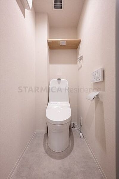 白を基調にした清潔感のあるトイレには、便利な棚板を設置。