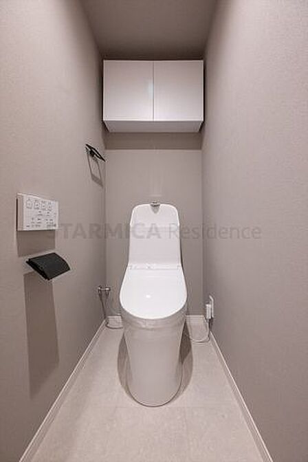グレージュカラーのアクセントクロスを採用したトイレ。パワー脱臭機能などを備えた温水洗浄便座付き。
