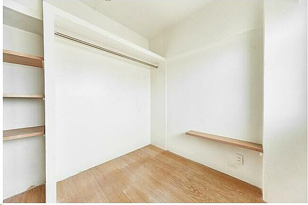 洋室の収納スペース。クローゼットハンガーと棚があります。
