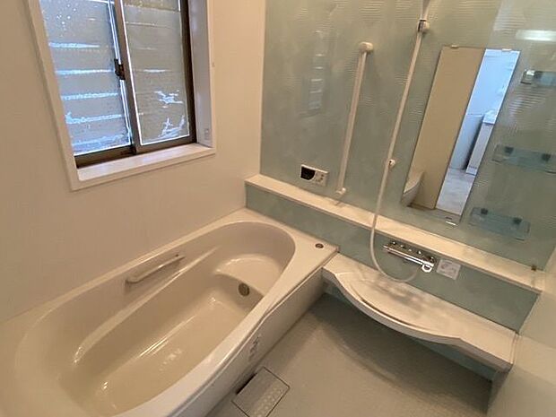 浴室の様子です。白と水色でかわいらしく清潔感がある浴室。浴槽は半身浴にもぴったりのベンチ付き。小さなお子様と一緒に入浴しても安心ですね。肘置きや手すりも付いています。立ち上がる時も楽そうです。