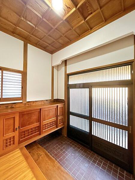 【リフォーム済】玄関を廊下側からの撮影です、床タイルはクリーニングを行い、壁クロスを張替え、照明・スイッチ類の交換をしました。玄関スペースは広々とした空間を確保しておりますので、毎日のお出かけも楽し…
