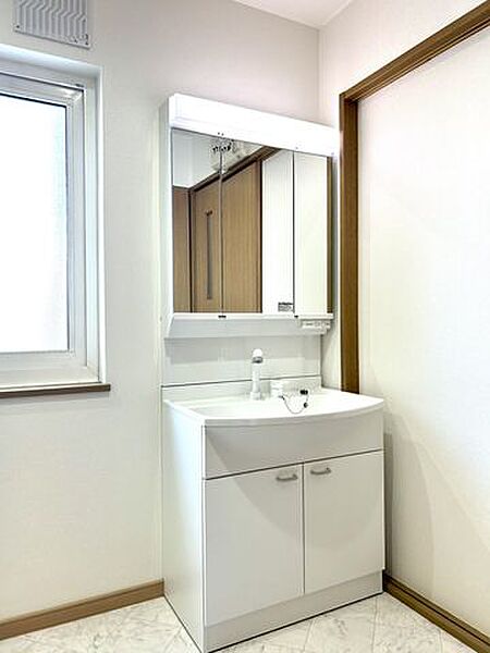 【リフォーム済】洗面化粧台はシャンプードレッサー三面鏡を設置いたしました。クロスを貼替し照明器具も交換致しました。