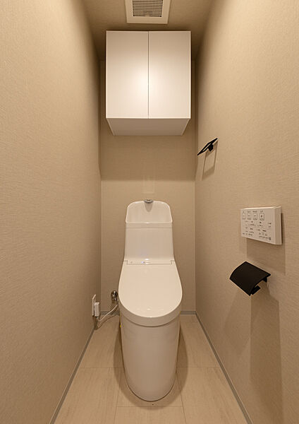 温水洗浄機能付きトイレで、上には便利な収納棚も備えています。