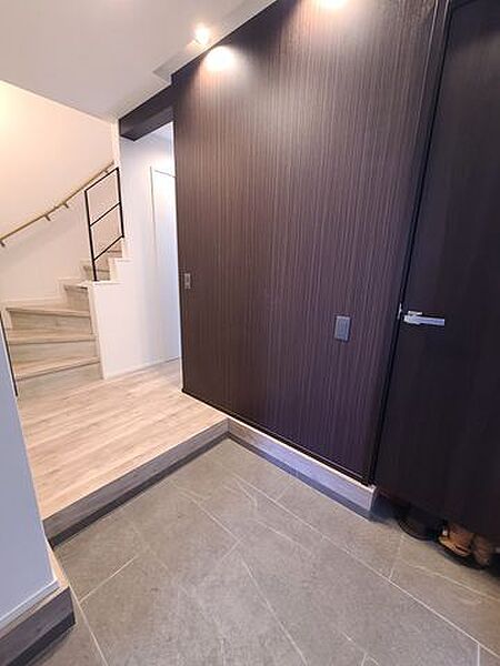 天井に埋め込まれたダウンライトが、壁面のテクスチャをドラマチックに照らし出します。