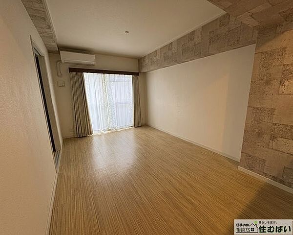 【デザイン性豊かなLDK】石目調のアクセントクロスが空間を上品に演出。温かみのある木目調フロアと相まって、洗練された心地よい空間が広がります。エアコン完備、陽当りも良好で一年中快適に過ごせます。