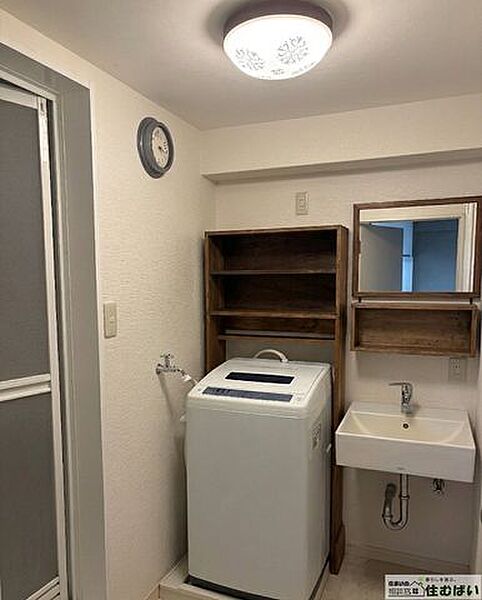 【木の質感が心地よい洗面室】温かみのある木製フレームの鏡と収納棚をカスタマイズ。洗濯機置場上部にも便利な棚があり、タオルや洗剤もスッキリ。毎日の身支度が楽しくなる空間です。