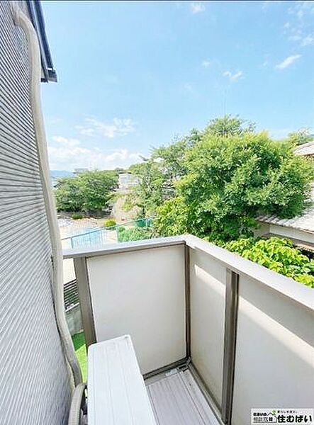 バルコニーからは、周囲の緑が望める開放的な眺望が広がります。視界を遮る建物が少なく、青空と木々の緑が心地よいプライベート空間。