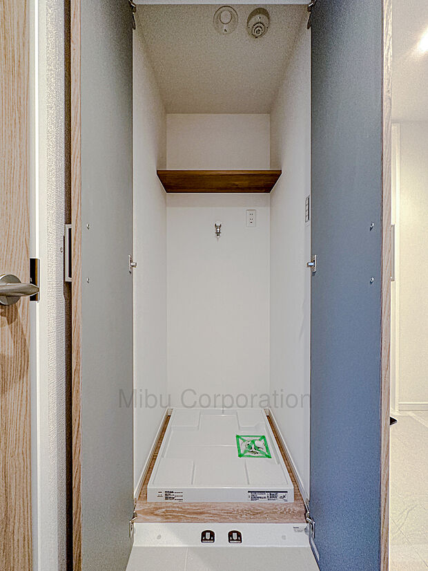 廊下に設置の扉付き洗濯機置場