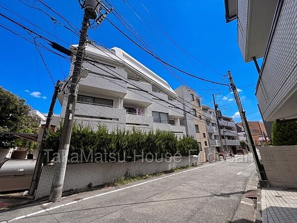 白を基調としたタイル貼りの外観。落ち着いた街並みに佇む、地上4階建の低層レジデンスです