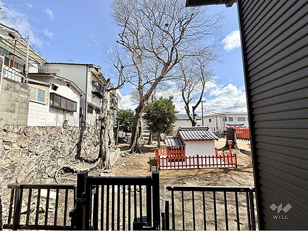 バルコニーからの眺め（東方向）です。「平五郎稲荷神社」の境内が見えます。［2026年3月19日撮影］