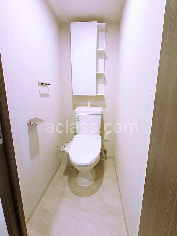 トイレ吊戸棚：トイレットペーパーやタオル、芳香剤などトイレ内で収納が完結できるように考えたサイズを確保しています。シャワートイレ暖房機能付便座だから、冬場も快適