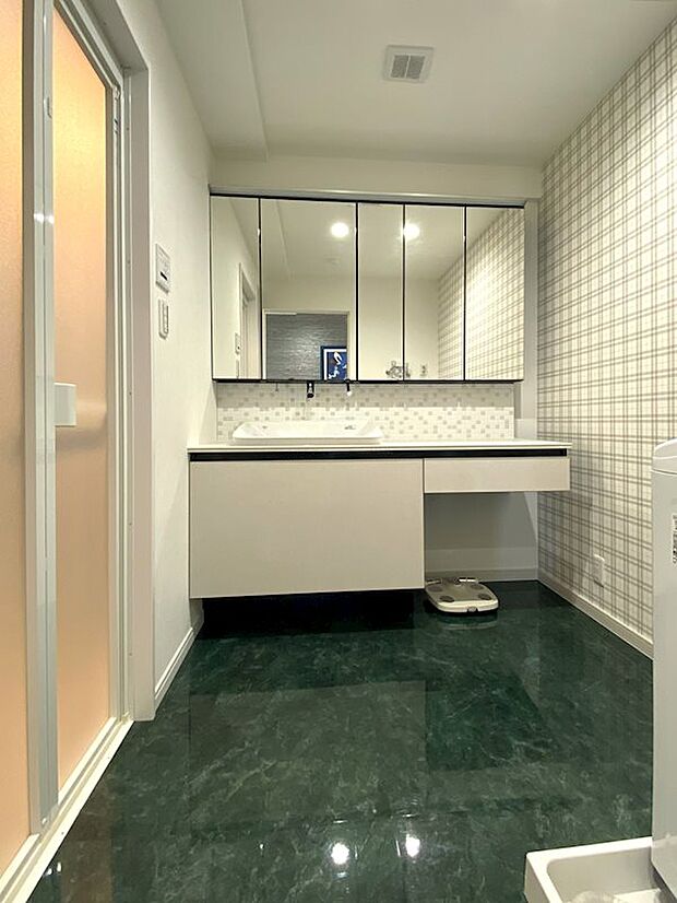脱衣スペースには大きな鏡の洗面台が設置されており、鏡裏収納スペースにも余裕があります。