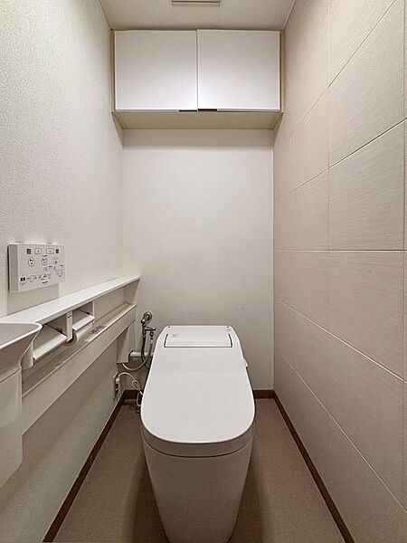 トイレはタンクレスを採用。手洗い器別のデザインです。壁面にはエコカラットが施工されています。