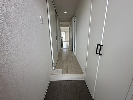 玄関から奥のLDKへと続く明るい廊下。手前には靴をたくさん収納できる大型シューズボックスを備えています。