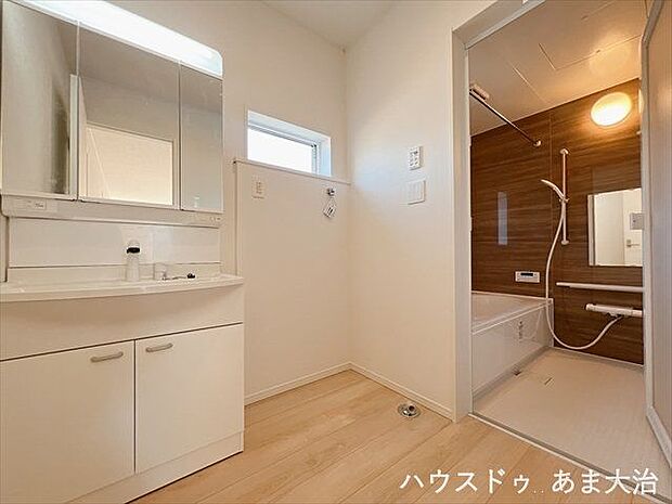 明るい色味の洗面所です。洗面台の横に洗濯機を配置しても、ゆとりのある脱衣場ですね。