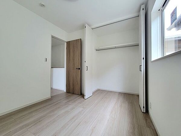 ハンガ―パイプつきのクローゼットのある洋室。