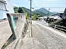 外観：別方向から見た前面道路です。道路の勾配や見通し、周辺の街並みを確認できます。