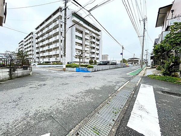 前面道路から見たマンション周辺の様子です。道路との接し方や建物へのアプローチをイメージしやすい写真です。
