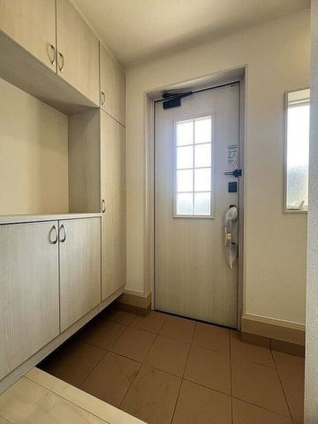 窓から光の入る明るい玄関で、家族やお客様をお迎えできます。