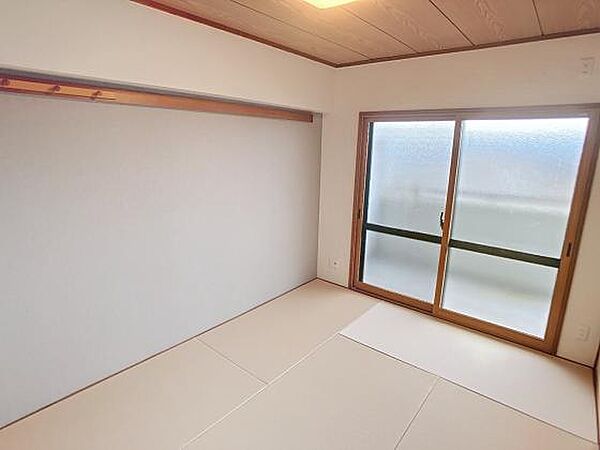 大きな窓と収納スペースのある和室。畳の香りが心地よく、落ち着いた雰囲気の空間です。